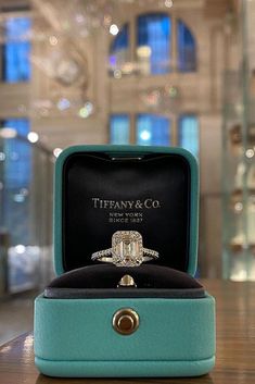 an engagement ring in a box on a table