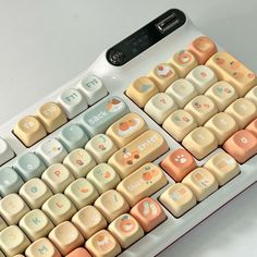 a computer keyboard with many different colored keys and numbers on the back side, sitting on a white surface