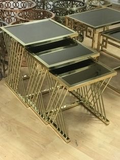 a set of three tables sitting on top of a hard wood floor next to chairs