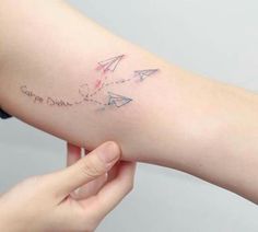 a woman's arm with an airplane tattoo on the left side of her arm