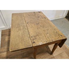 an old wooden table sitting on top of a hard wood floor