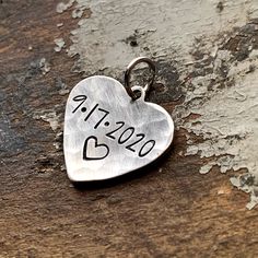 "Perfect little heart charm with your special date wedding, anniversary, birth, first date, you choose the day and we'll stamp it for your to wear. Need to add an extra charm to your necklace or bracelet? Add on charms are perfect with all of our custom stamped jewelry or to add onto a necklace or bracelet you already own. 5/8\" small silver heart charms are handstamped in a modern font and can include a date, initials and ampersand or a name. Charms are silver alkeme', which is a metal alloy th Personalized Charms For Anniversary And Valentine's Day, Stamped Heart Jewelry For Anniversary, Heart-shaped Stamped Jewelry For Anniversary, Heart Shaped Stamped Jewelry For Anniversary, Heart Pendant Charms For Anniversary And Mother's Day, Heart-shaped Wedding Charms For Valentine's Day, Heart-shaped Charms For Wedding And Valentine's Day, Personalized Heart Charms For Anniversary, Engraved Charms For Valentine's Day Anniversary