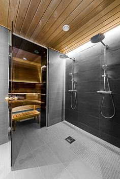 a bathroom with a wooden ceiling and glass doors that lead to the sauna room