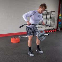 a man holding a barbell while standing in a gym