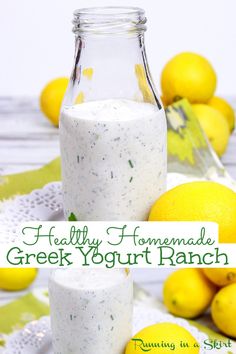 a bottle filled with greek yogurt ranch next to lemons