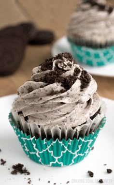 two cupcakes with chocolate frosting and oreo cookies on the top one