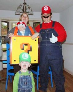 two adults and a child standing in front of a table with an object on it