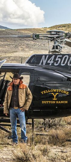 a man standing in front of a helicopter