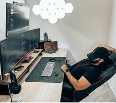 a man sitting at a desk in front of a computer monitor with headphones on