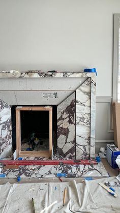 a fireplace being built in the middle of a room with construction tools on the floor