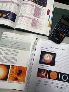 a calculator sitting on top of an open book next to a calculator