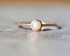 a gold ring with a white pearl on it