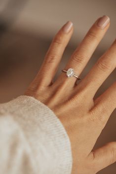 a woman's hand with a diamond ring on it