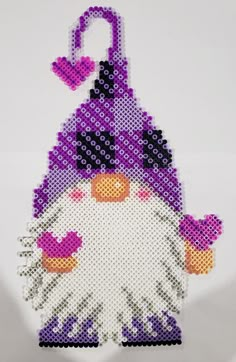 an ornament made to look like a snowman with purple and black hat