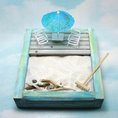 a miniature beach scene with chairs and an umbrella