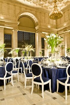 a banquet room with blue linens and white flowers