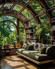 a living room filled with lots of books and furniture next to a window covered in plants