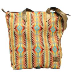 Product number: A770000002. Stylish Southwestern multi-colored print tote. Durable cotton-blend canvas material. Fastened with zipper closure and metallic brown leather straps. Features embossed tan Ariat logo. Size: 15" x 6" x 16". Ariat Logo, Southwest Print, Cowgirl Accessories, Ariat Boots, Southwestern Print, Leather Belts Men, M F, Brown Leather Strap, Tote Purse