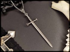 Simple Occult Sword Necklace. You can choose between 2 colors. You can also find different matching earrings in my shop: https://www.etsy.com/de/listing/1307602320/valkyrie-silber-schwert-ohrringe-okkulte?click_key=762339c72a17285ca46f7c0559e53ac8f2bfe7b9%3A1307602320&click_sum=3e8a2b71&ref=shop_home_active_5&pro=1 https://www.etsy.com/de/listing/969953439/warrior-silber-schwert-ohrringe-in-3? click_key=b7f62c2be0da42196ebb42a3fec11063144a259a%3A969953439&click_sum=013cd762&ref=shop_home_active_ Gothic Jewellery, Witch Necklace, Celtic Necklace, Necklace Gothic, Witch Jewelry, Gothic Necklace, Gothic Jewelry, Shop Home, Gift Packaging