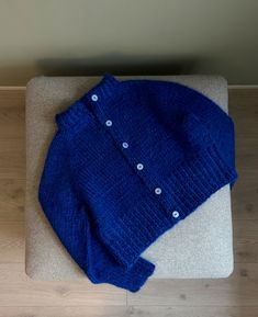 a blue sweater laying on top of a wooden floor