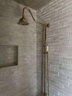 a shower head and hand held shower faucet in a bathroom with white brick walls