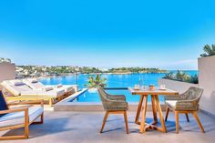 an outdoor dining area with chairs and table next to the pool in front of it