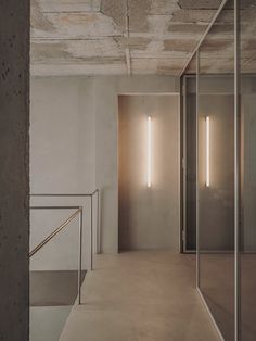 an empty room with some lights on the wall and stairs leading up to another room