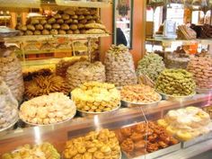 a display case filled with lots of different types of sweets and candies in bowls