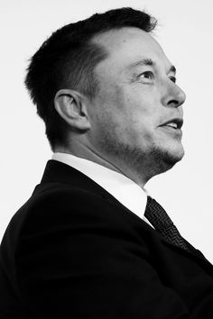 a black and white photo of a man in a suit looking off into the distance