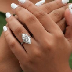 a woman's hands with white manicured nails and a diamond ring