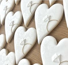 several white heart shaped cookies are arranged on a table