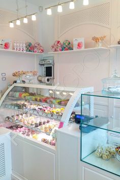 a display case filled with lots of different types of cakes and cupcakes on shelves