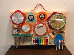 a wooden toy display with lots of different toys on it's sides, including drums and other musical instruments