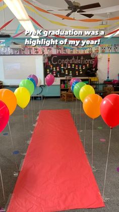 balloons and streamers are on the red carpet in front of a whiteboard with congratulations written