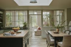 a kitchen filled with lots of counter top space and wooden tables topped with chairs next to each other