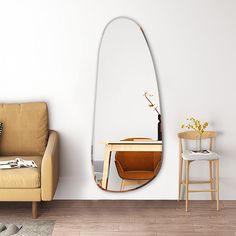 a living room with a chair, table and mirror on the wall next to it