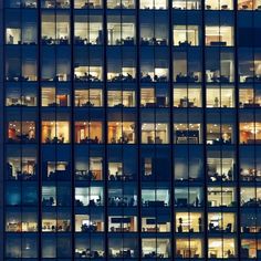 an office building at night with lots of windows lit up in different colors and sizes