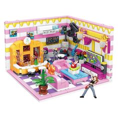 a toy house with a woman walking in front of it and toys on the floor