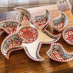 three decorative plates sitting on top of a wooden table