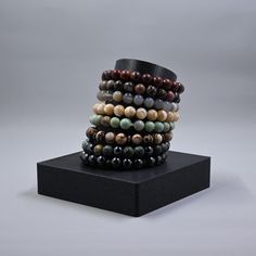 a stack of bracelets on top of a black stand