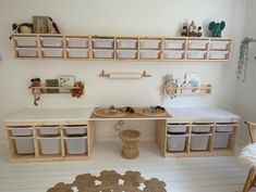 a toy kitchen with lots of toys on the counter and shelves above it in a playroom