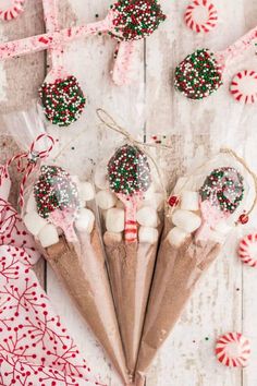 candy canes wrapped in cellophane and sprinkles on top of white wood