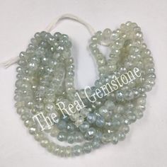 the beads are white and light blue with some green on them, as well as an inscription