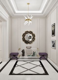 a living room with white walls, black and gold accents and a chandelier hanging from the ceiling