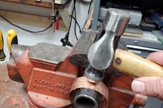 a man is holding a hammer in his hand while working on a piece of wood