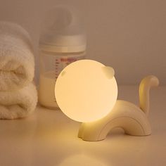 an elephant shaped night light next to towels and a baby's pacifier bottle