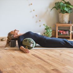 a woman is laying on the floor with her legs crossed and head resting on an object