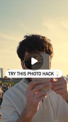 a man taking a photo with his cell phone in front of the camera text reads try this photo hack