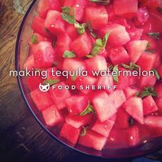 a bowl filled with watermelon on top of a wooden table