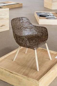 a brown chair sitting on top of a wooden platform next to other pieces of furniture